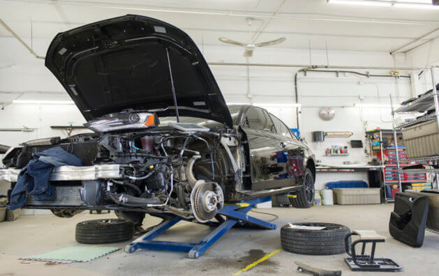 An open black car being repaired.