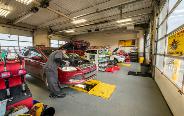 A man repairing a car at Minit Lube in Taylor Drive.