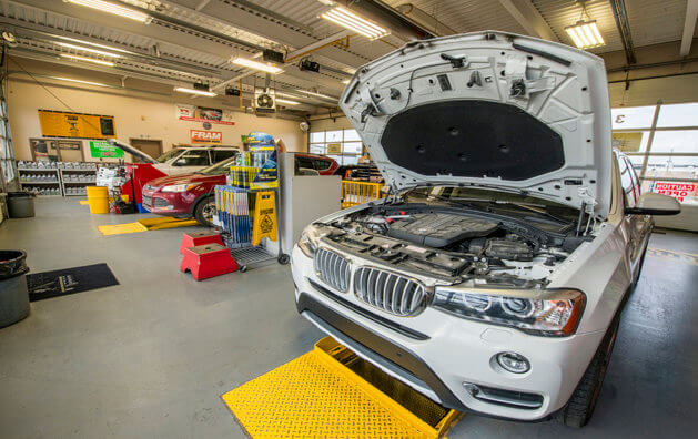 Call with an open hood in Minit Lube's working area.