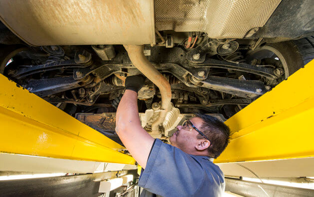 A man working in the underside of the car.