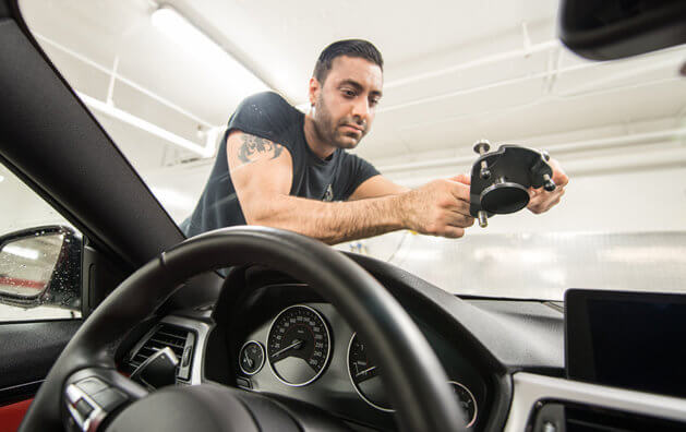 A man repairing a windshield.