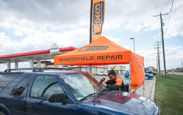 A man repairing a windshield.