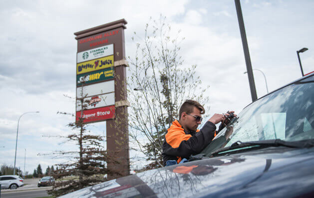 A man repairing a windshield.