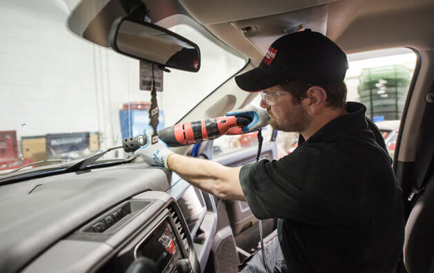 employee working in car front glass