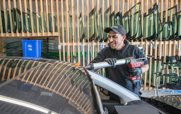 A man working on windshield replacement.