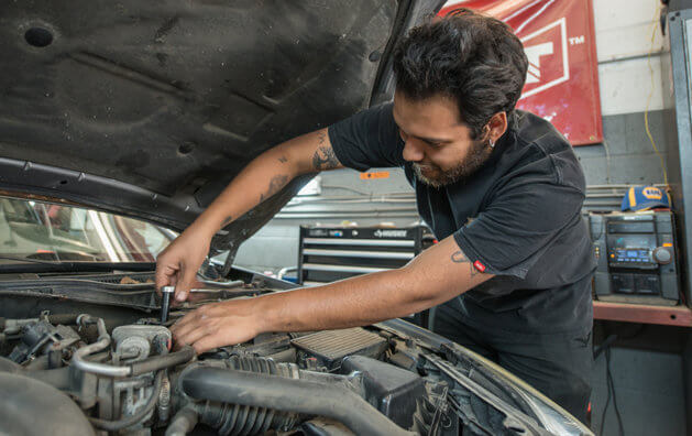 A man working in the engine of the car.