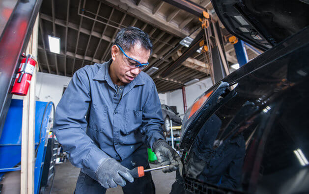 mechanic repairing car front light