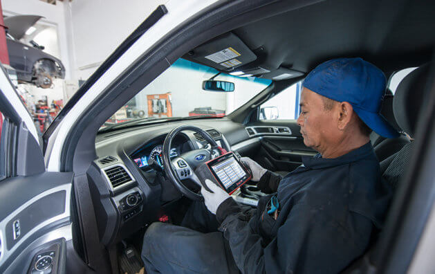 auto mechanic checking auto from the front seat