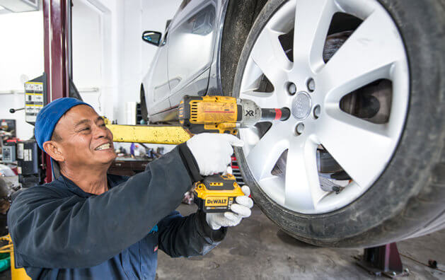 mechanic adjusting the tire bolts on the car
