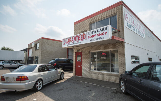 front of the company with red door, entrance to the garage and cars entering