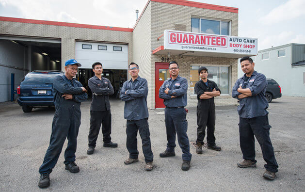 six workers of the GUARANTEED AUTO CARE company, in front of the repair shop
