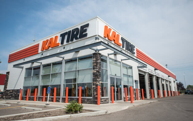 Elevated poster of the company at the entrance of the parking lot, there is a large showcase of its items for sale