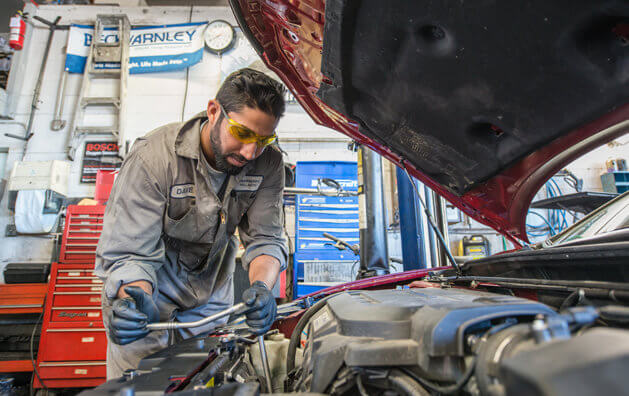 Service technician checking engine diagnostics at Strawberry Hill Auto in Surrey, BC