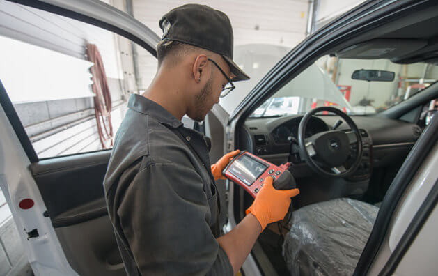 A man working with a vehicle diagnostic reader