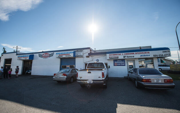 Frontis of Jim's Automotive Langley with a white van and a green car parked and waiting to be served.