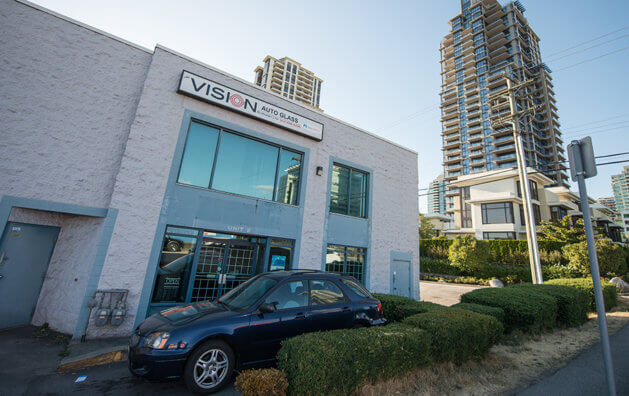 Frontis of Vision Auto Glass Burnaby with a blue car parked.