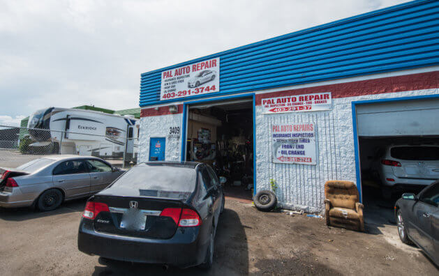 Outside the Pal Auto Repairs shop, the main entrance, you can see a parked several car.