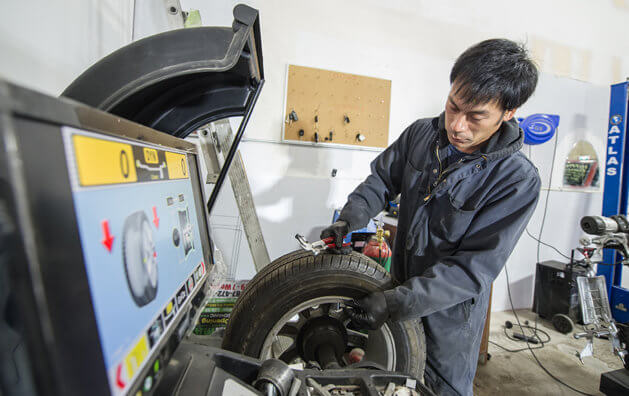 Mechanic holding tire in Carmax Auto Care Center