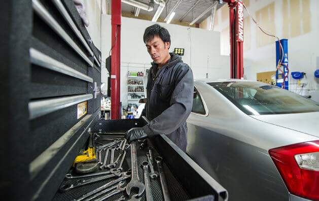 Service technician checking engine diagnostics at Carmax Auto Care Center