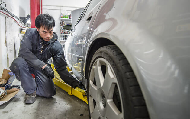 Service technician checking tire at Carmax Auto Care Center